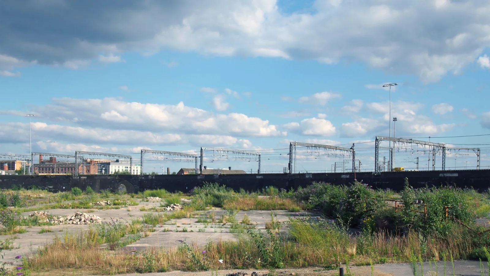 Disused brownfield commercial land beside railway infrastructure in Leeds, England.